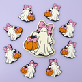 Ghost girl with bow and pumpkin clay cutter with finished polymer clay charms on purple background